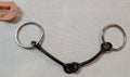 Black and silver horse bridle bit on a light gray background