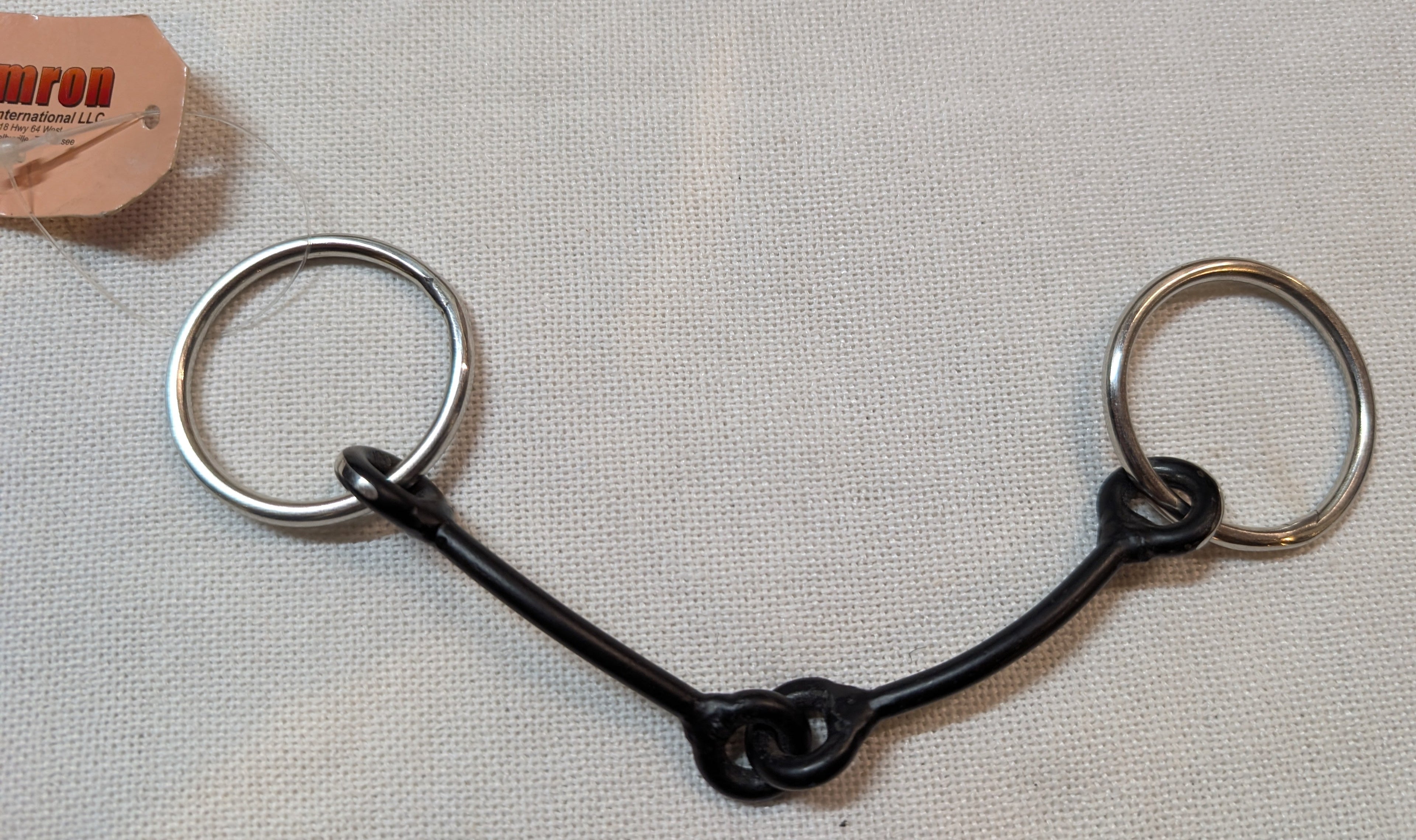 Black and silver horse bridle bit on a light gray background