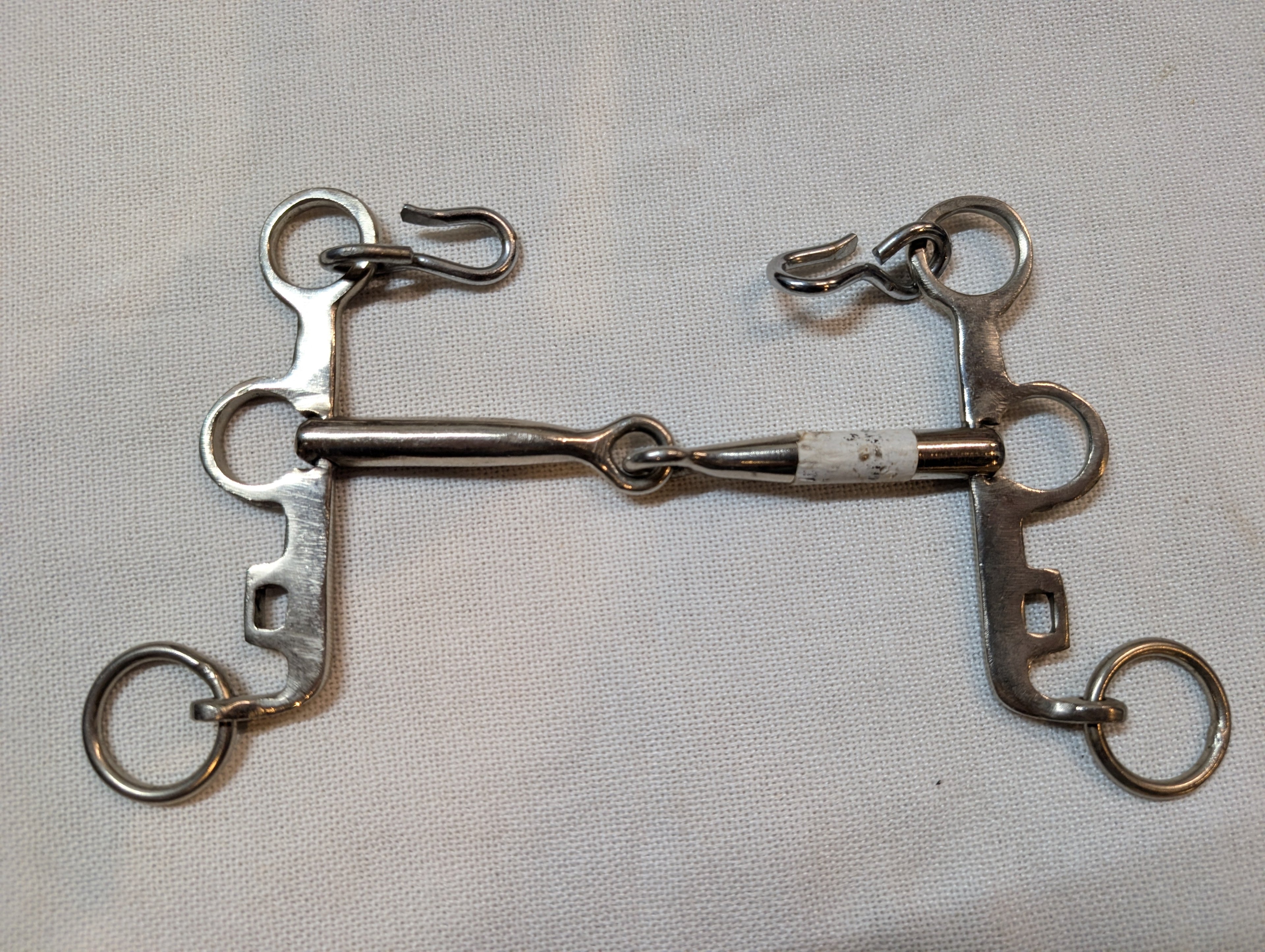 Metal horse bridle on a light gray background