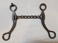 Metal bridle bit on a light fabric background
