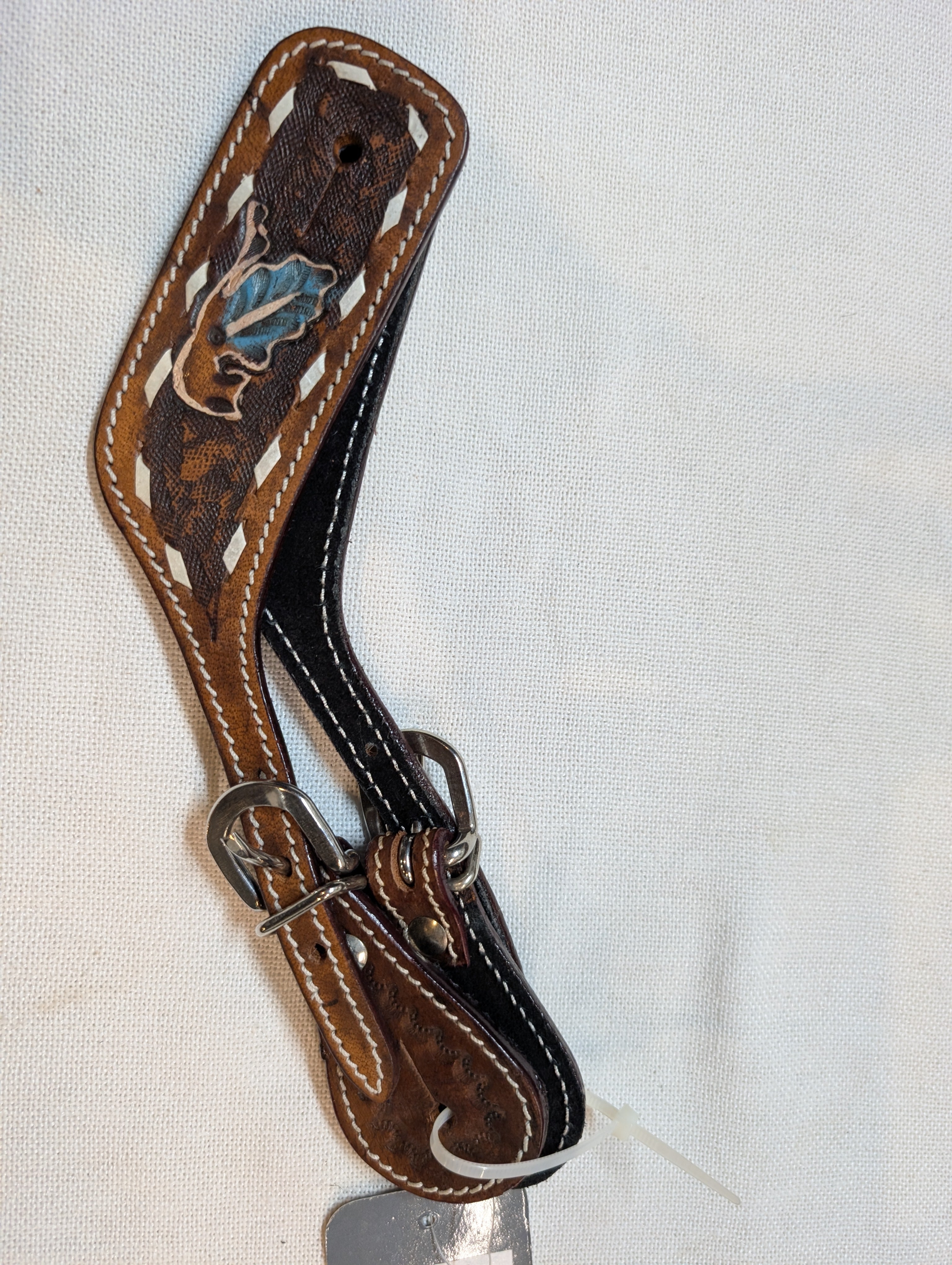 Brown leather spur strap with decorative stitching on a white background