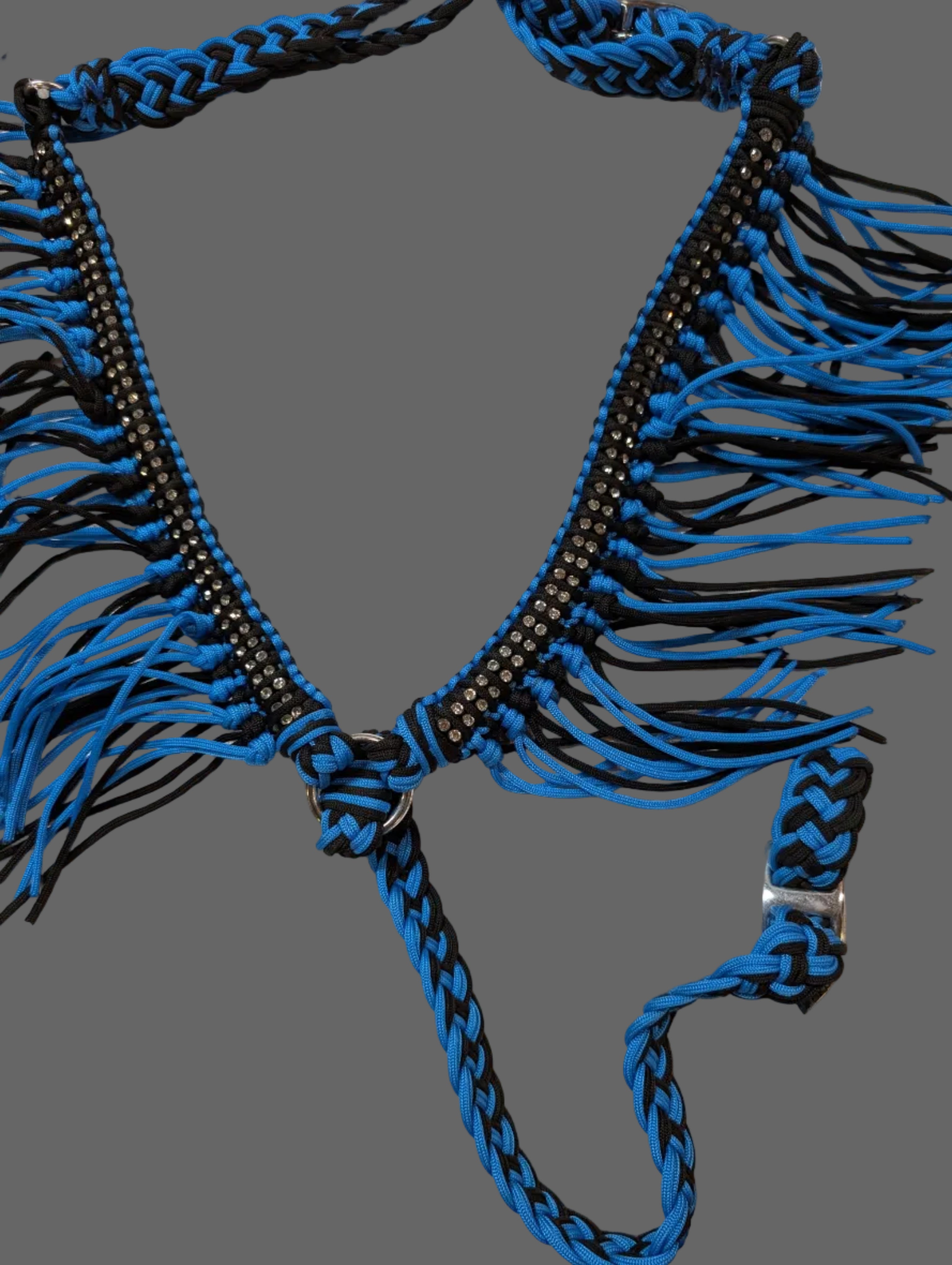 Blue and black braided breast collar on a beige surface