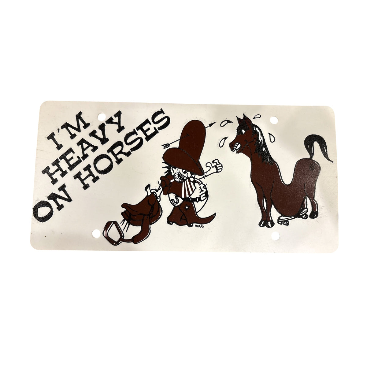 A plastic licence plate, featuring a cartoon illustration of a sweating horse, and fighting cowboy and saddle with the text 'I'M HEAVY ON HORSES' on a plain white background.