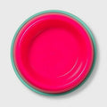 Pink bowl with green rim on a light gray background