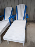 Two white lounge chairs with blue armrests and backrests on a concrete floor.
