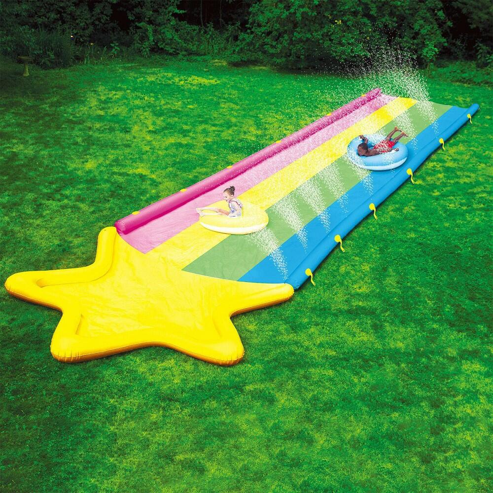 Colorful inflatable water slide on grass with people 