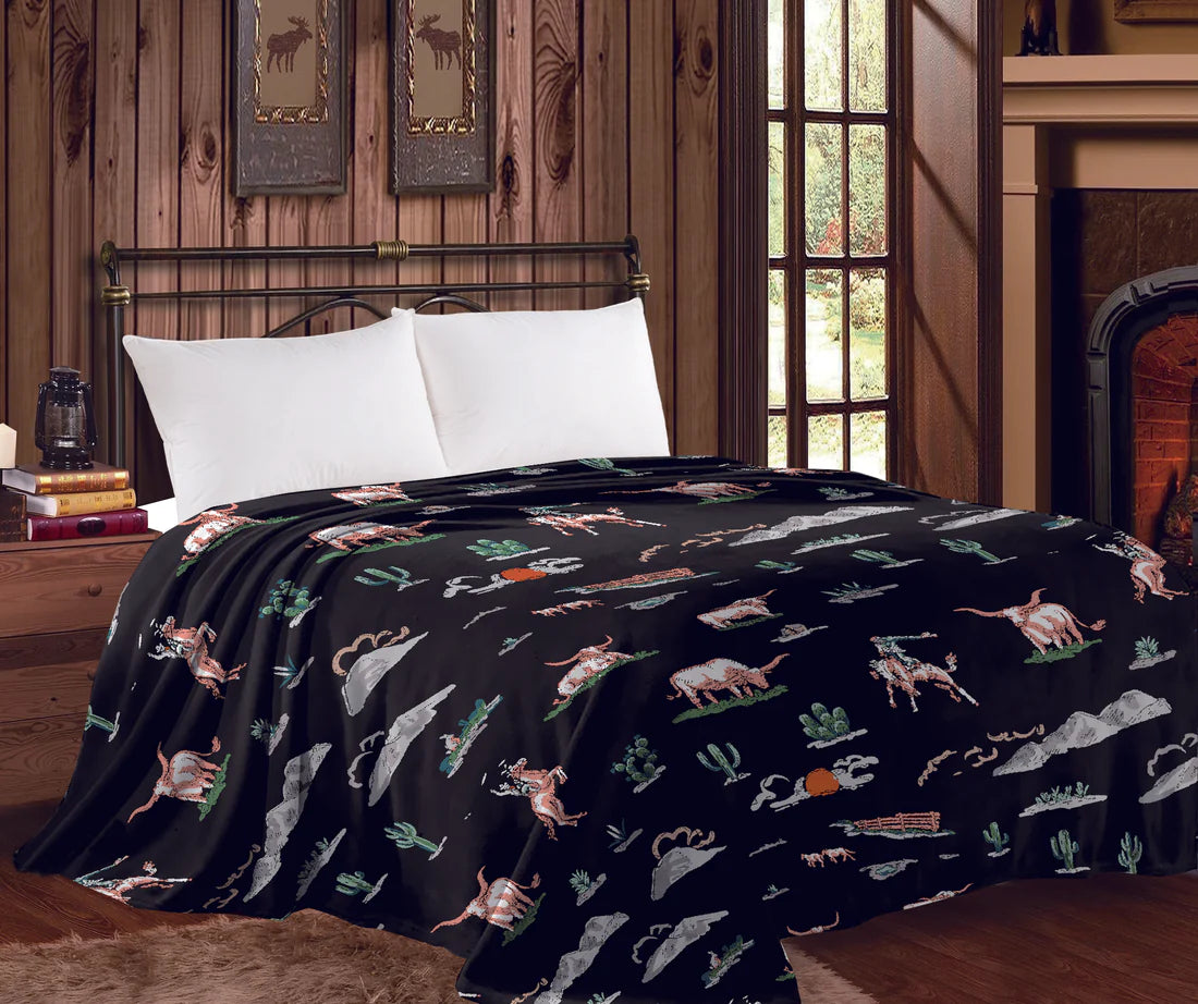 Bed with black blanket featuring animal patterns in a room with wooden walls and a fireplace.