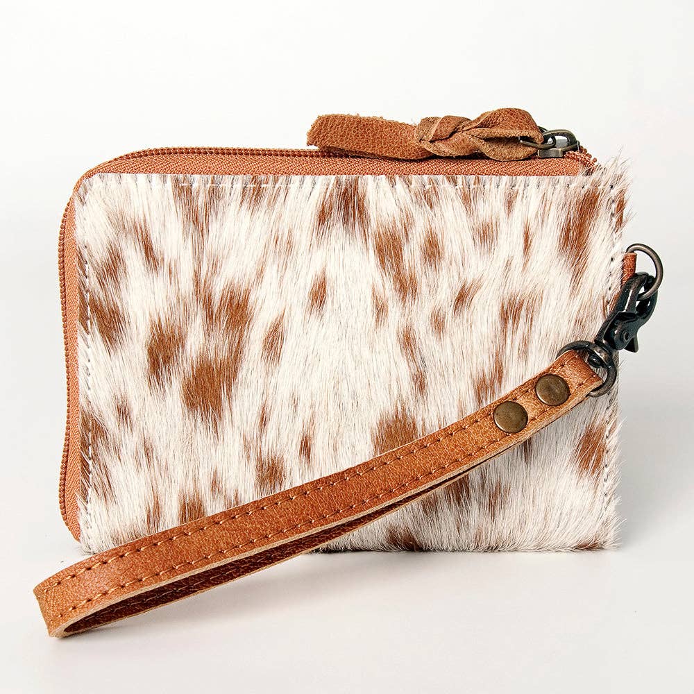 Small pouch with cowhide pattern and brown leather strap on a white background