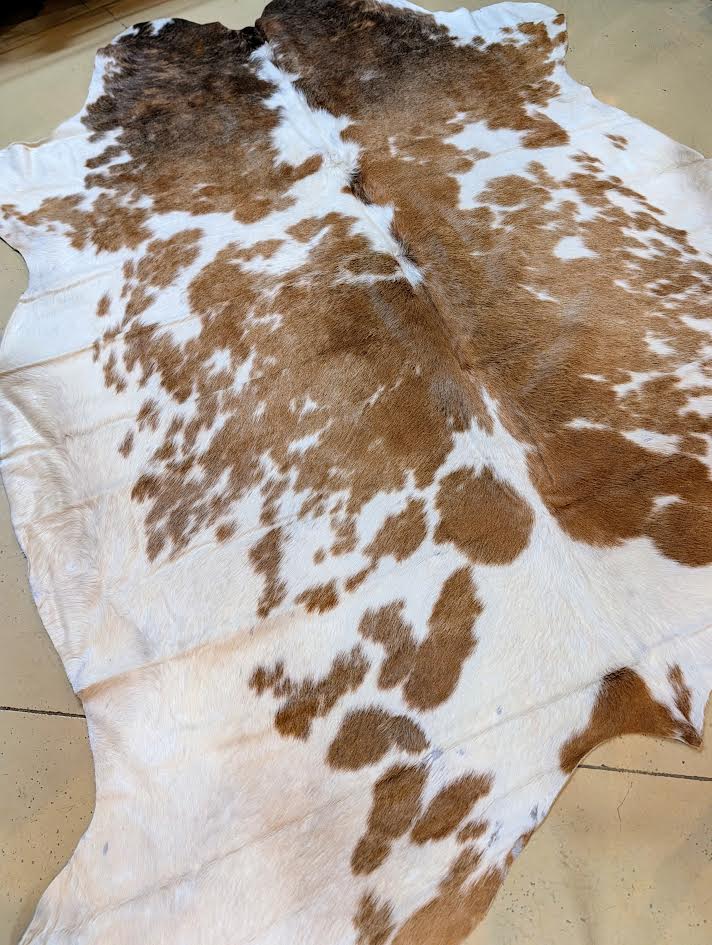 Red and white cowhide rug on a tiled floor