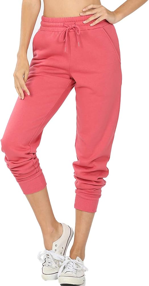 Pink sweatpants worn by a person on a white background