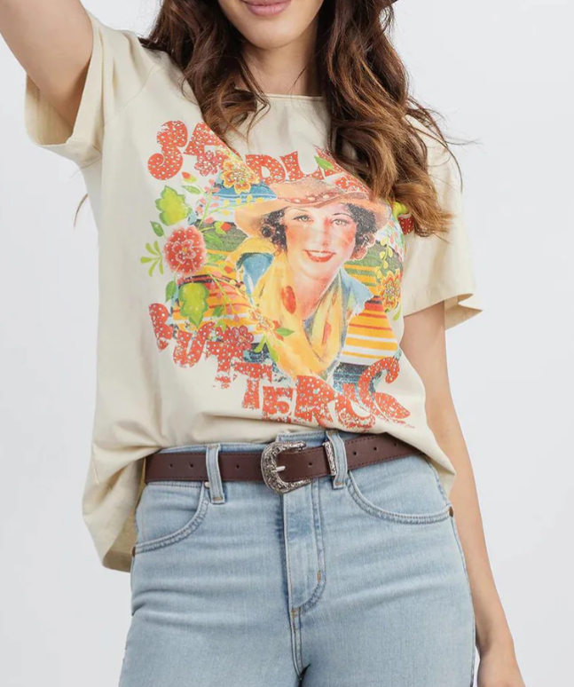 Person wearing a graphic t-shirt with a colorful design and light blue jeans on a white background