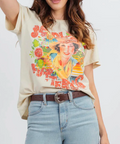 Person wearing a graphic t-shirt with a colorful design and light blue jeans on a white background