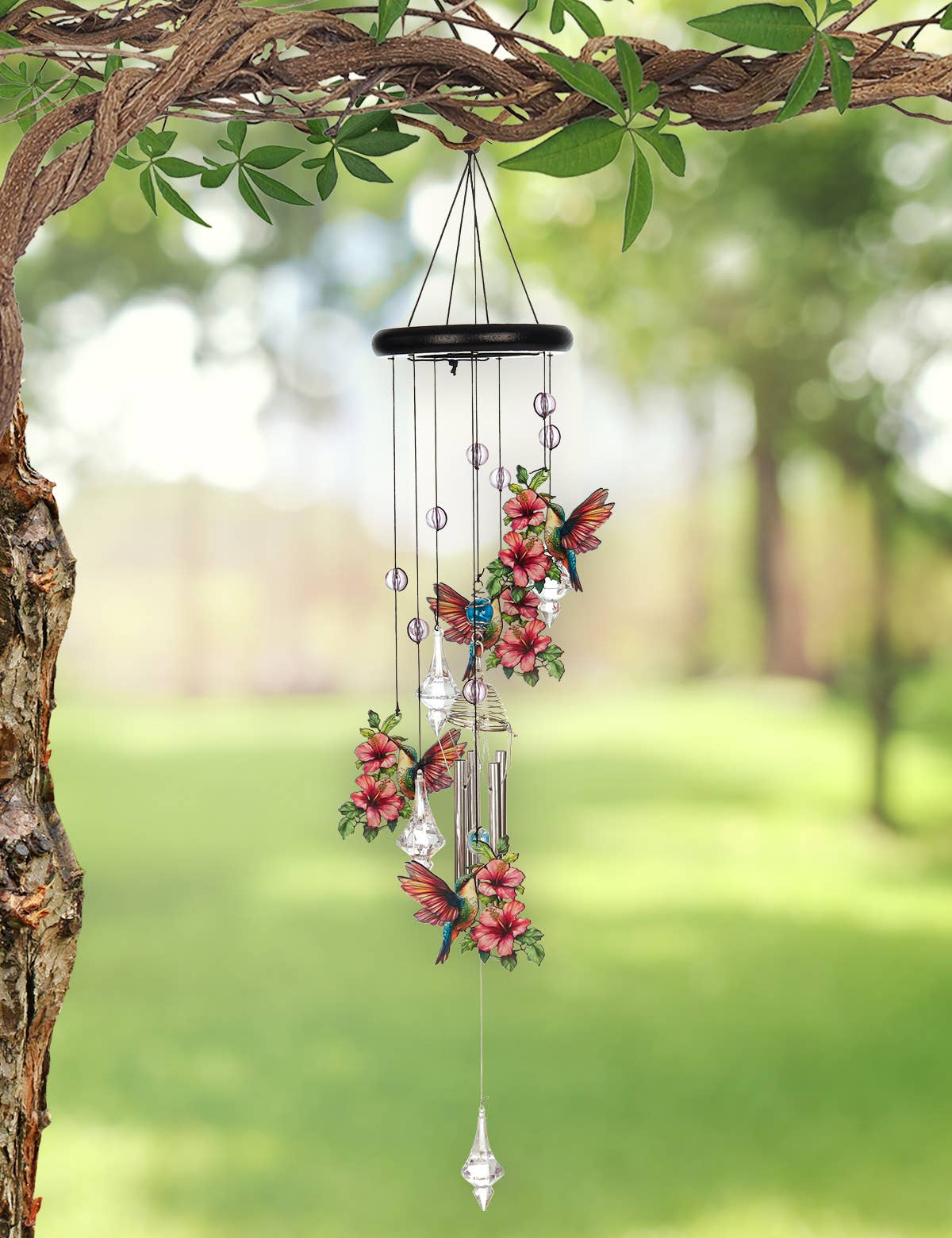 Decorative wind chime with floral and butterfly designs hanging from a tree