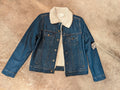 A Sherpa-lined dark wash denim jacket laid flat on a surface.