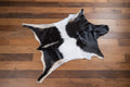 Black and white goat hide  rug on a wood floor