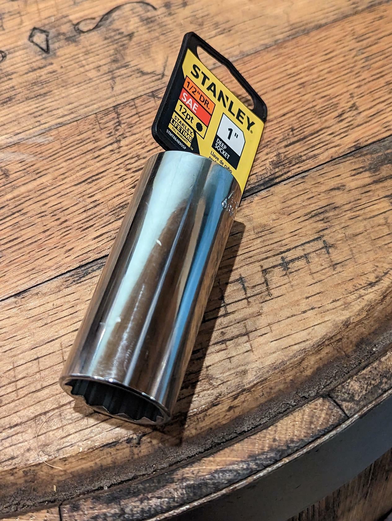 Metal Deep Socket made by Stanley on a wood surface