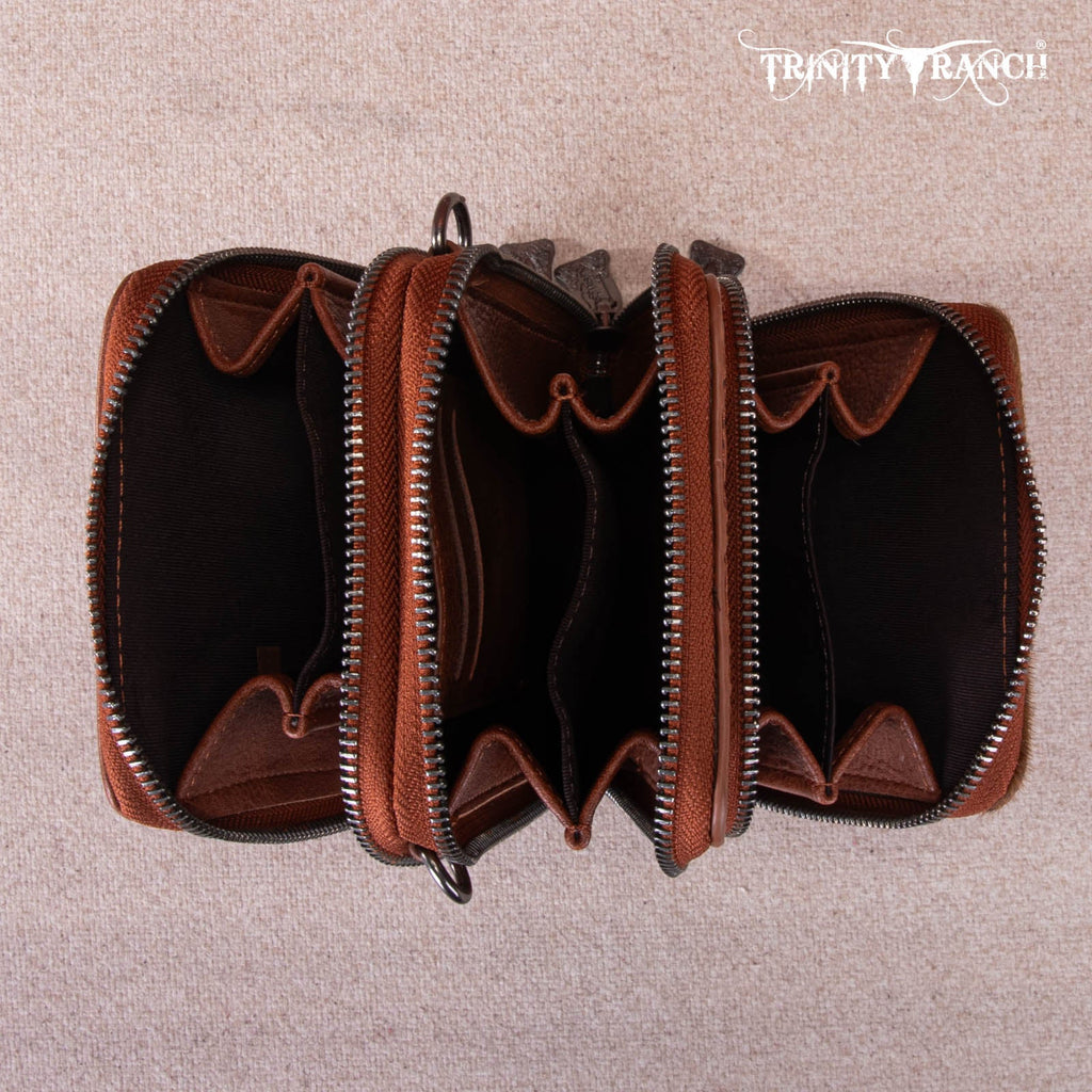 Brown leather wallet with zippers on a beige background, featuring 'Trinity Ranch' branding.