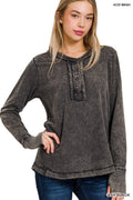 Woman wearing an acid wash black long-sleeve shirt on a white background
