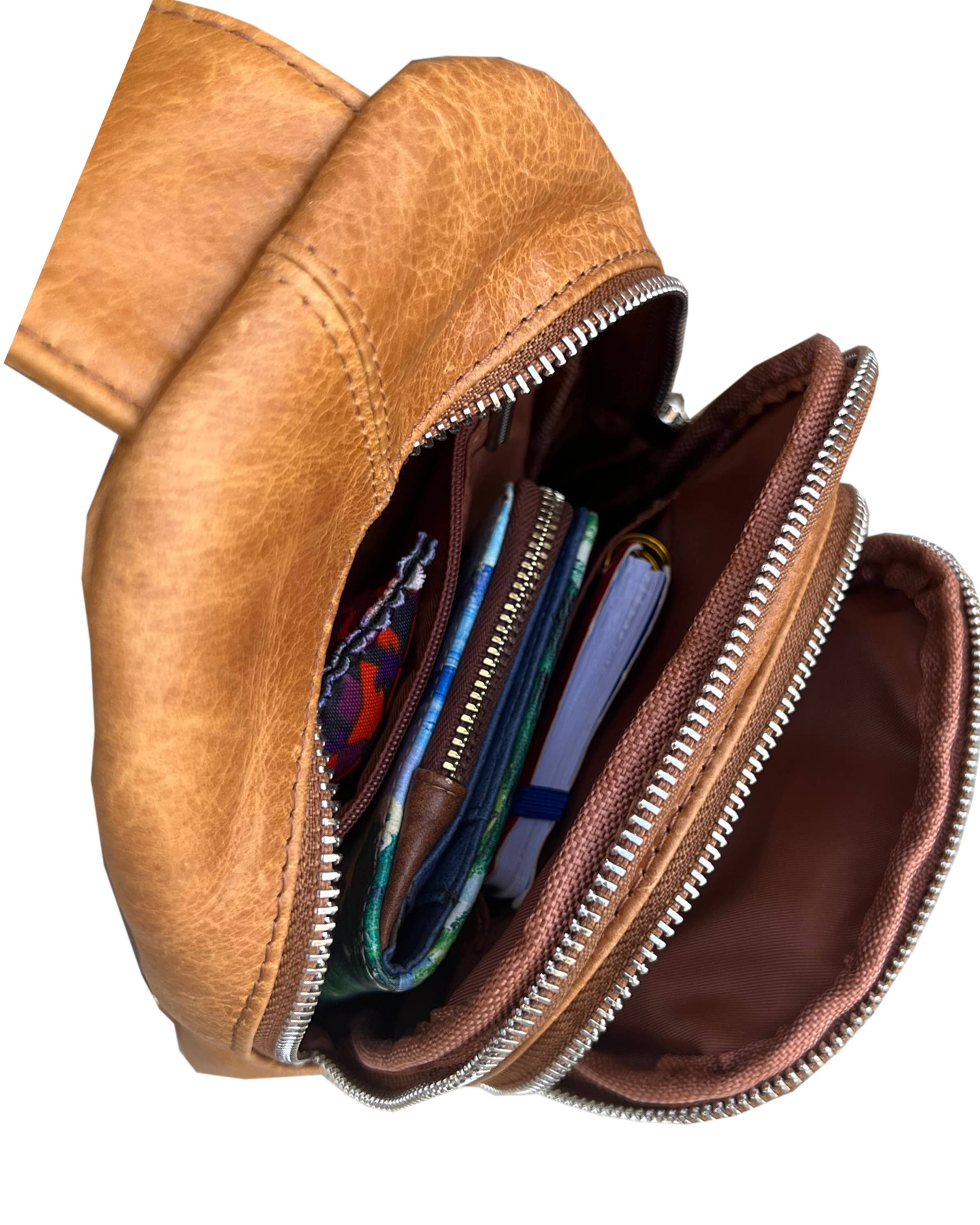 Brown leather pouch with zippers open, revealing colorful contents on a white background