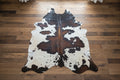 Black and white cowhide rug on a wood  floor