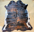 Brown and black cowhide rug on a beige floor