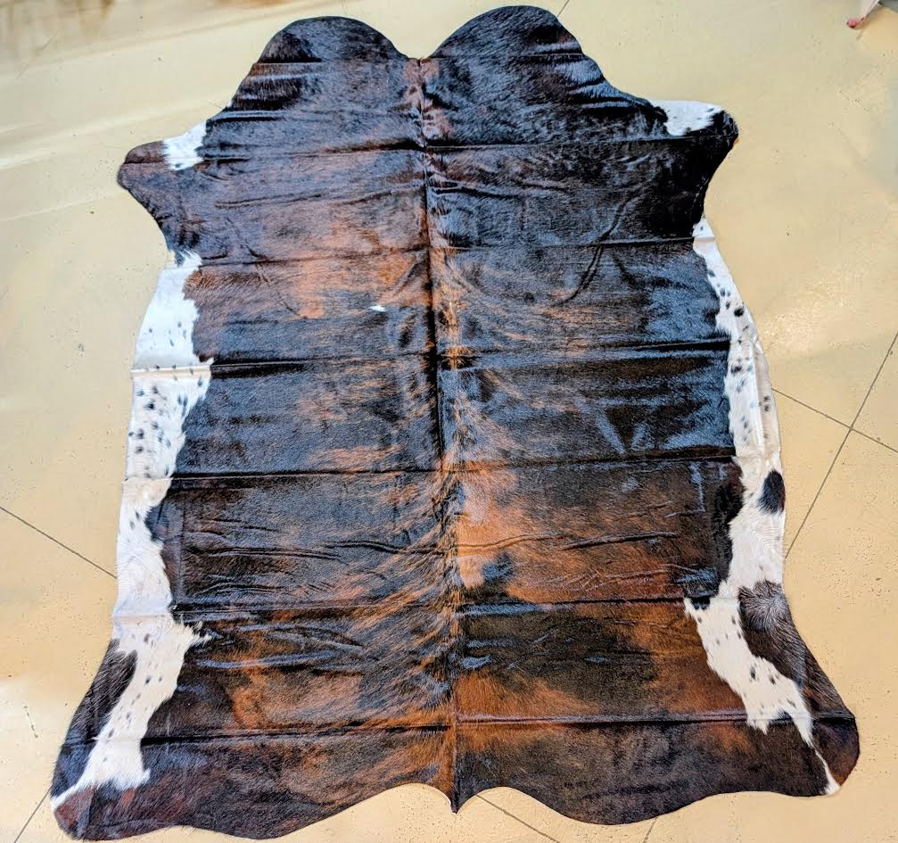 Brown and black cowhide rug on a beige floor