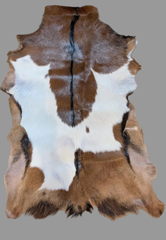 Brown and white goat hide rug on a tiled floor
