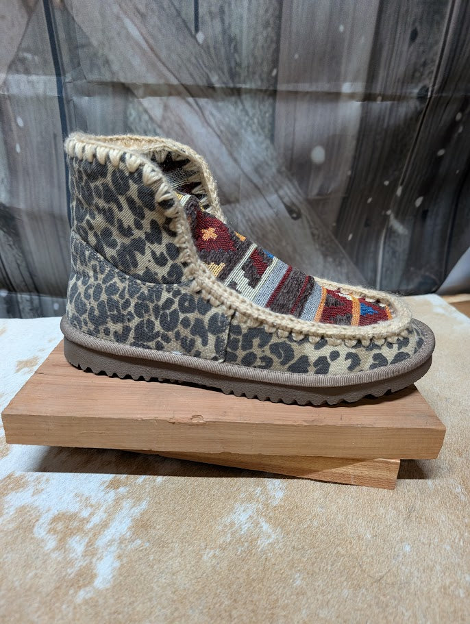 Leopard print boot with patterned sole on a wooden block