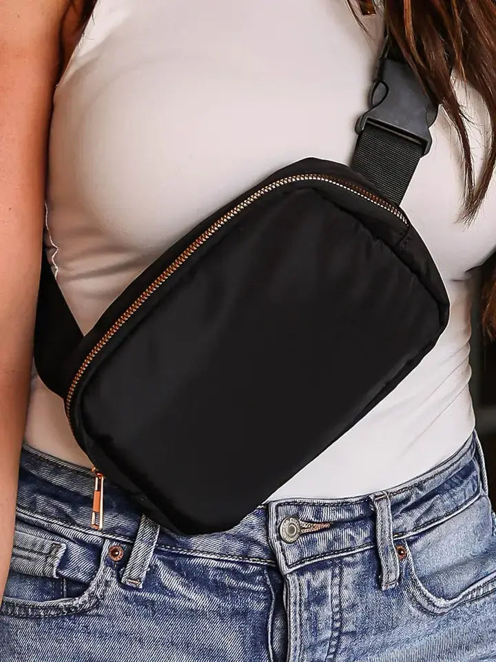 Black Crossbody bag on a lady wearing a white top and blue jeans