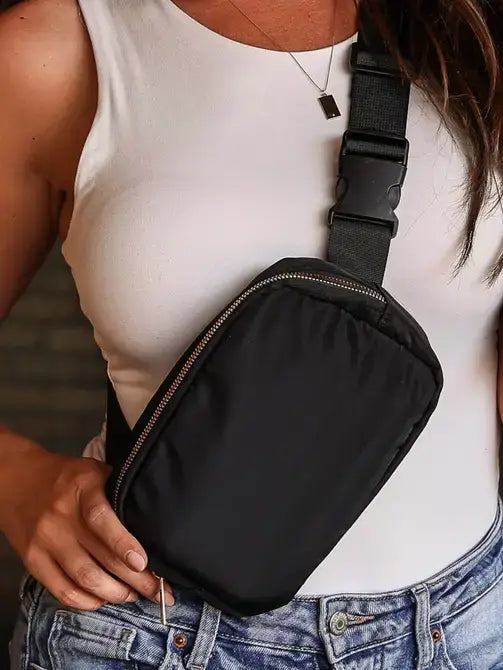 Person wearing a black crossbody bag with a blurred background