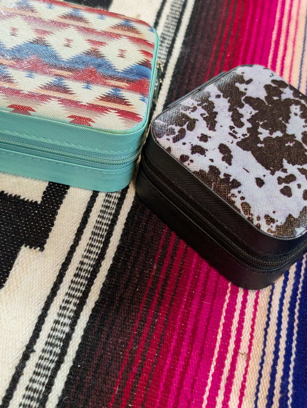 Western-style mini jewelry box open with rings and earrings inside
