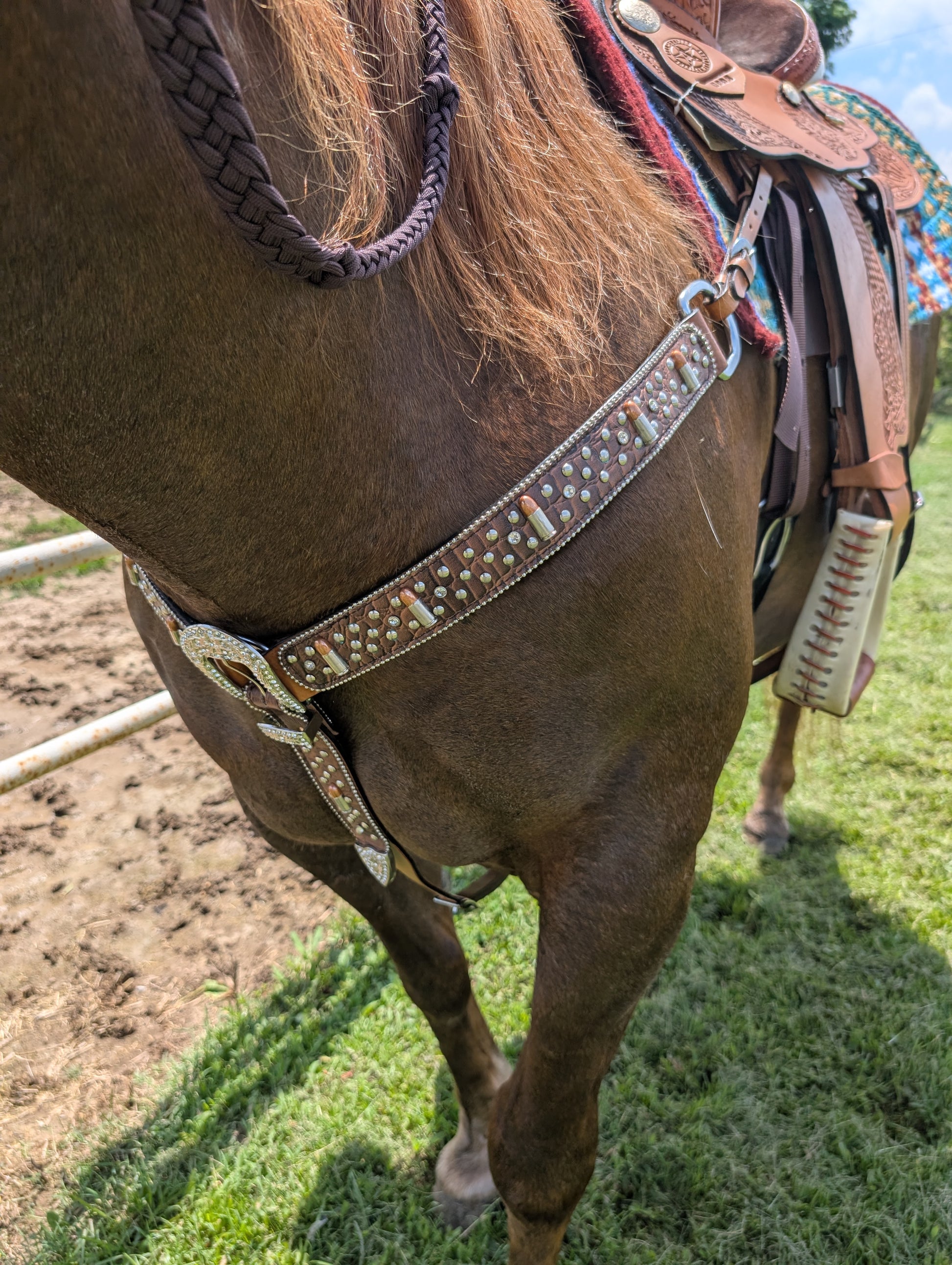 Close-up of crystal-accented buckle with copper and silver bullet conchos