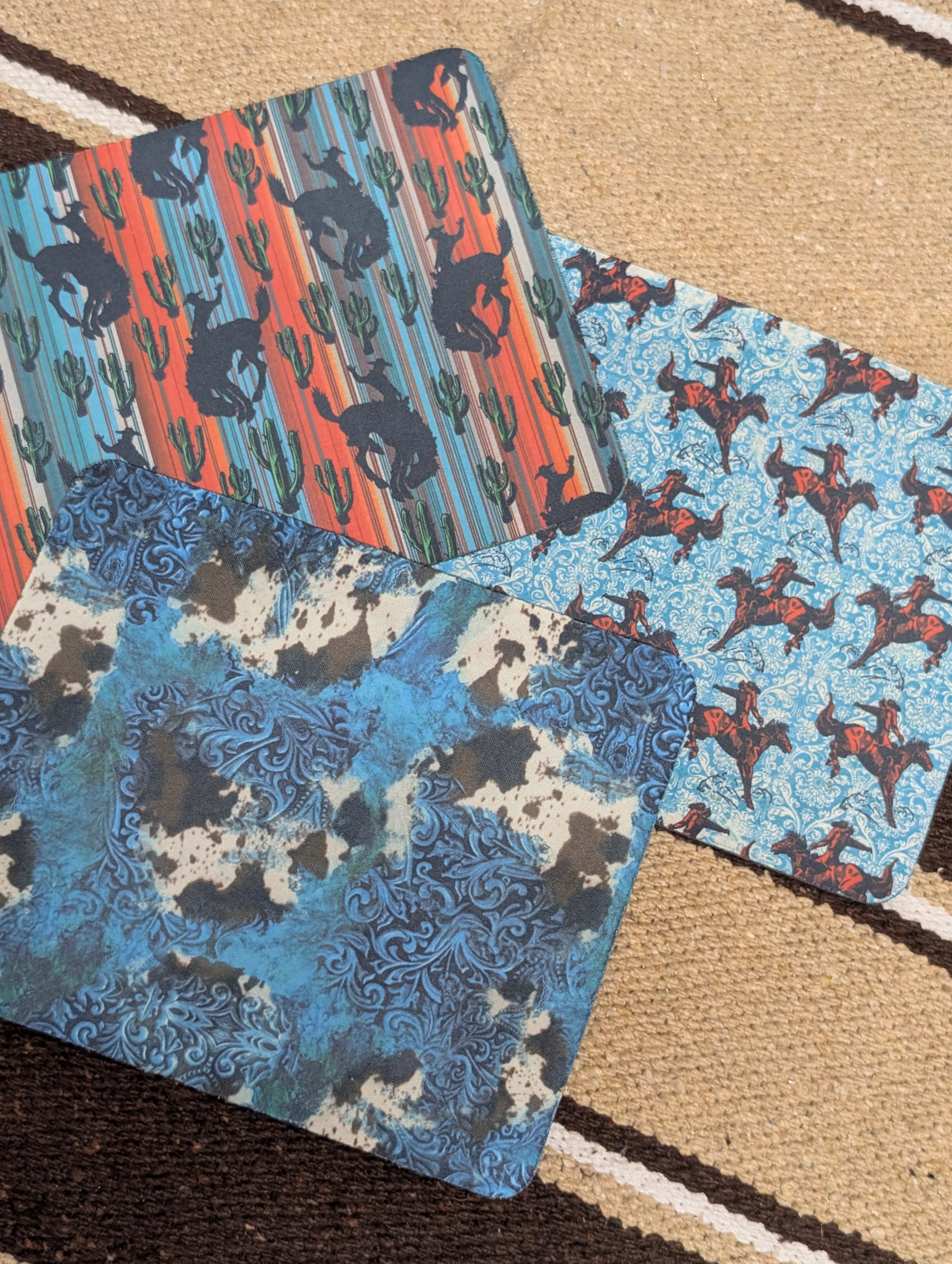 Four fabric swatches with different patterns on a textured surface