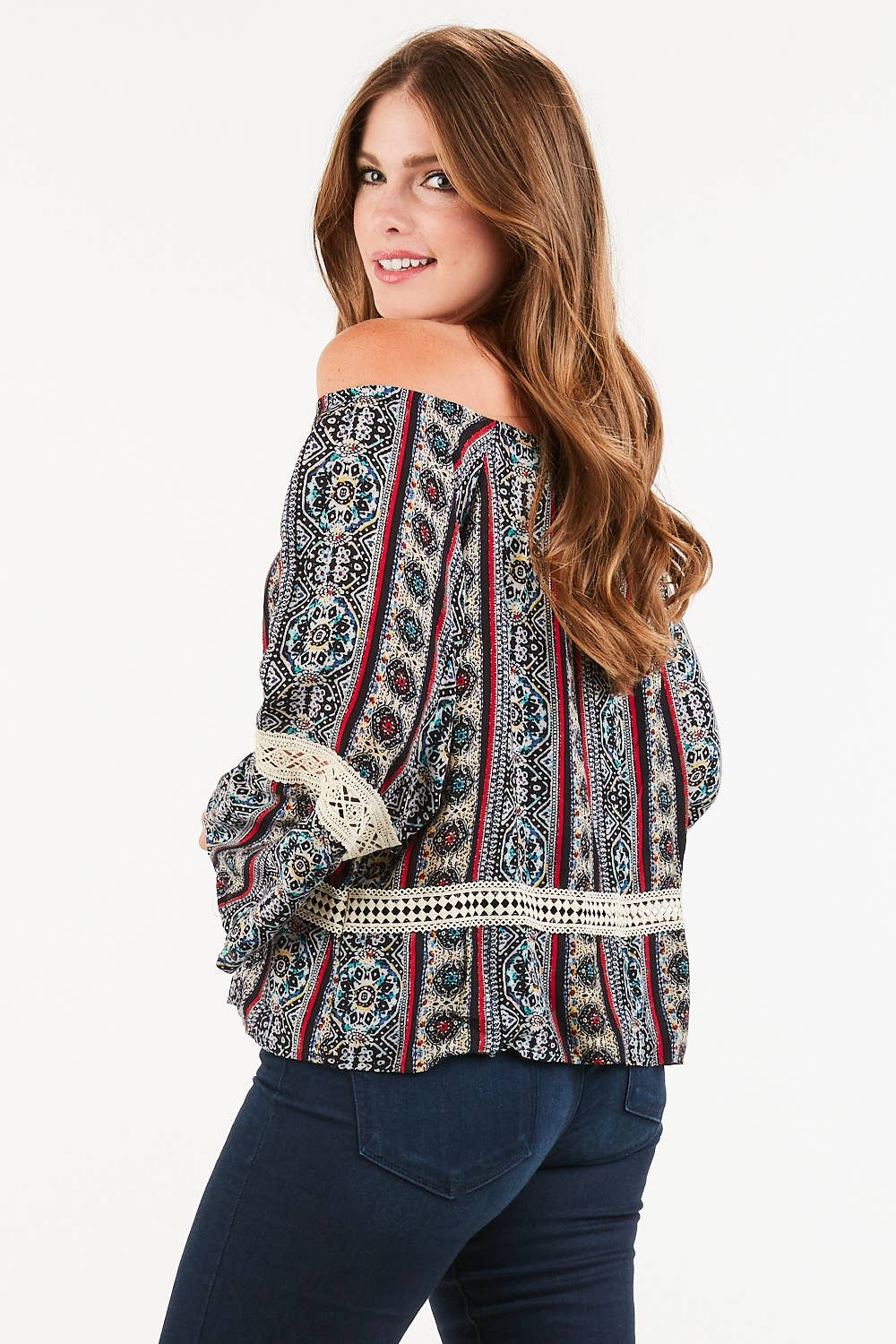 Close-up of paisley print and tassel trim on women’s off-shoulder top