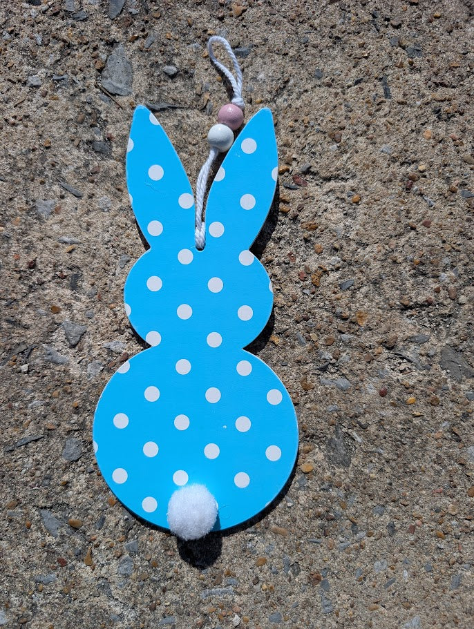 Blue polka dot bunny toy on a concrete surface