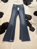 Pair of blue jeans with a tag on a cow print background