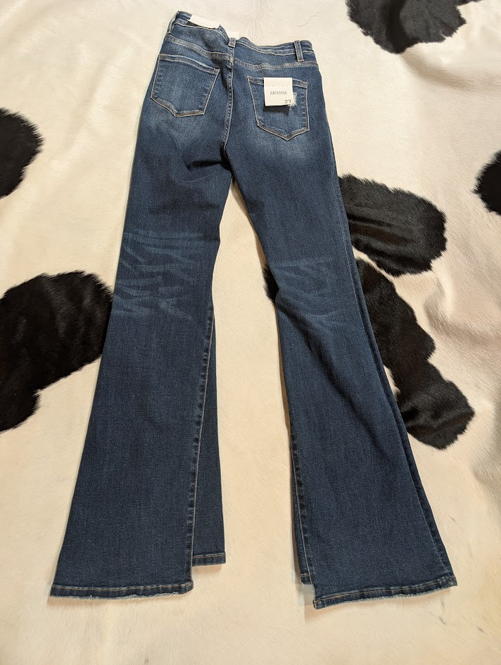 Pair of blue jeans on a black and white cowhide rug.
