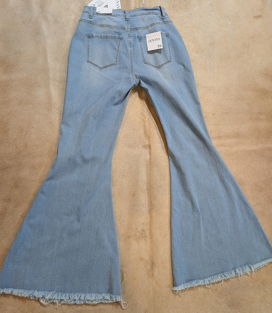 Blue jeans with a tag on a beige carpet