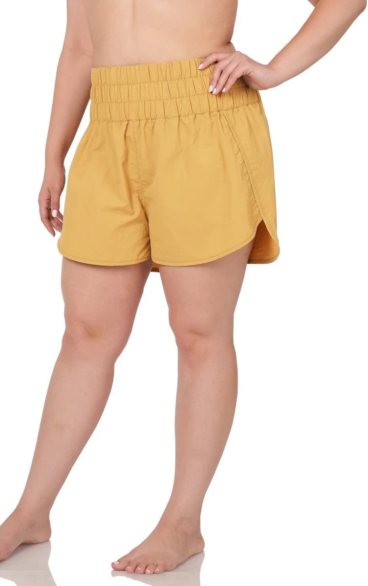 Yellow shorts worn by a person on a white background