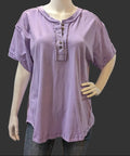 Mannequin wearing a purple short-sleeve shirt with buttons with a gray background