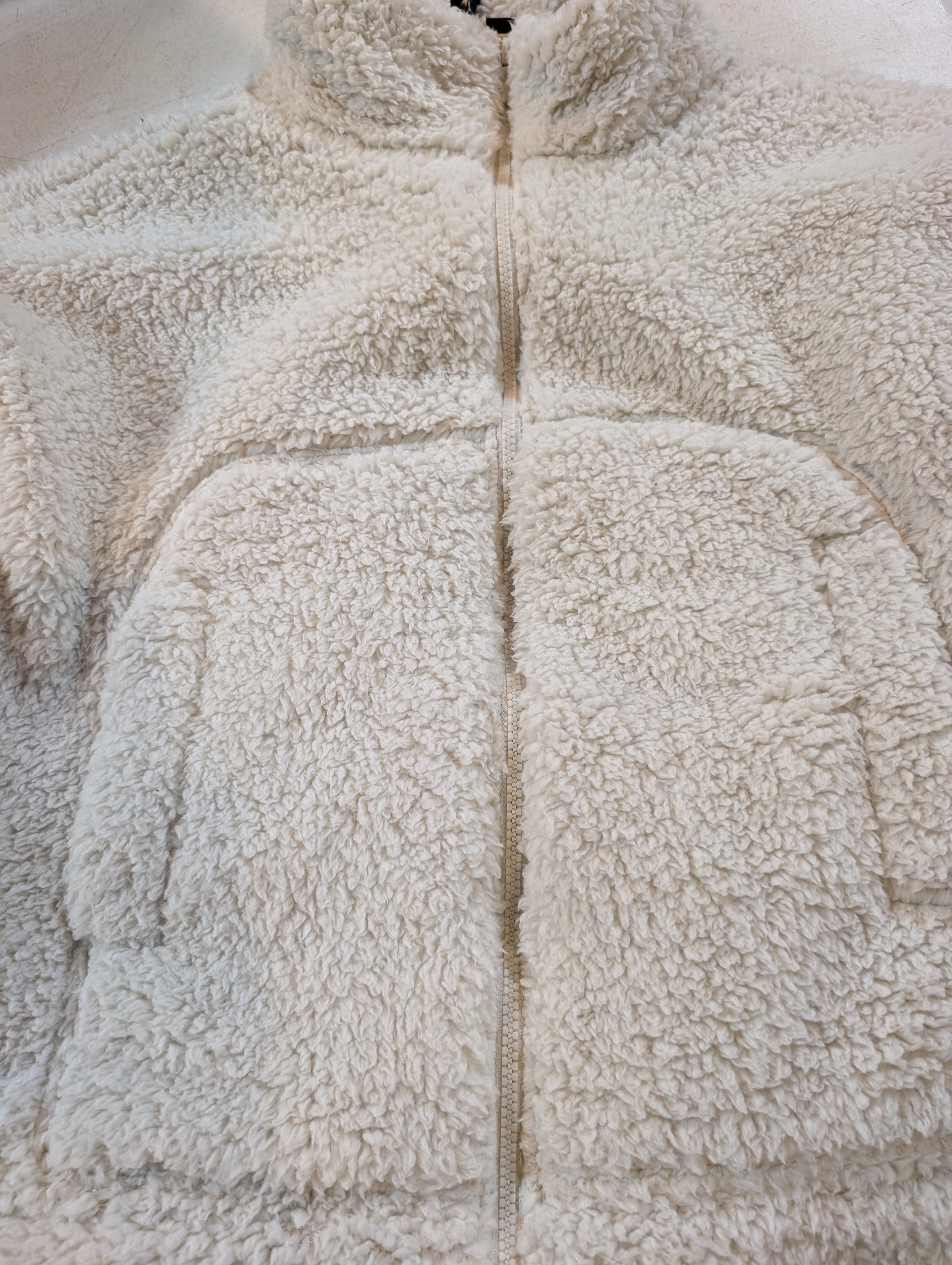 Close-up of a textured beige fabric with a zipper