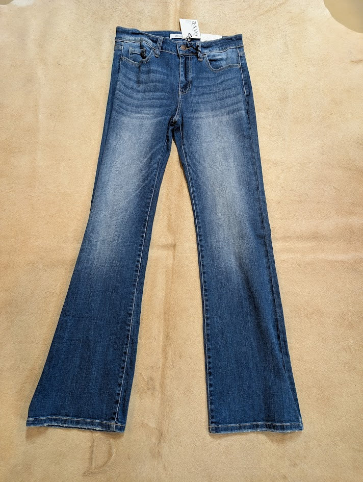 Zenana women’s medium wash mid-rise bootcut stretch denim jeans laid flat on rustic background