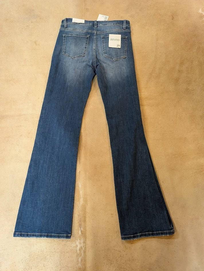 Blue jeans on a beige surface