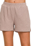 Beige shorts worn by a person on a white background