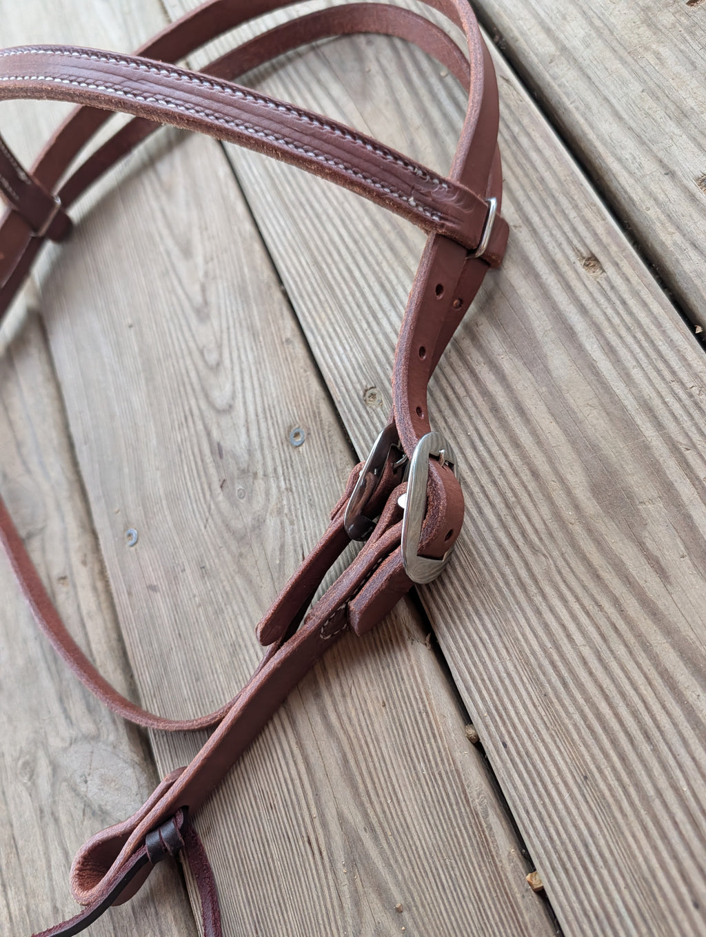 Amish made brown leather browband headstall with silver buckle hardware on a wooden plank background.