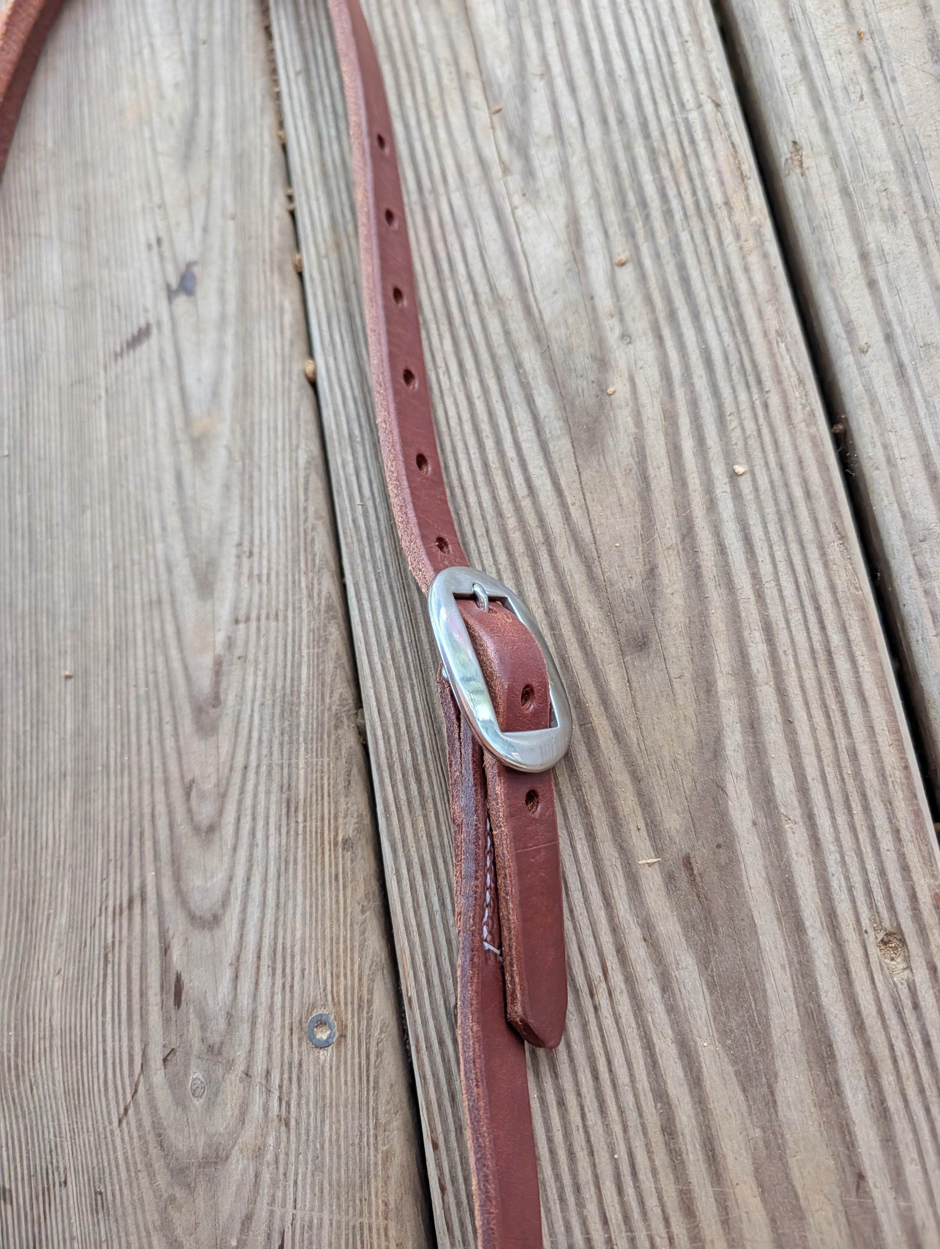 A up-close of a Amish made leather split ear headstall stainless buckle.