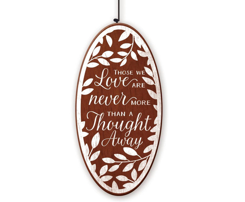 An oval wooden hanging sign with a brown background and white distressed text that reads, "THOSE LOVE ARE NEVER MORE THAN A THOUGHT AWAY"