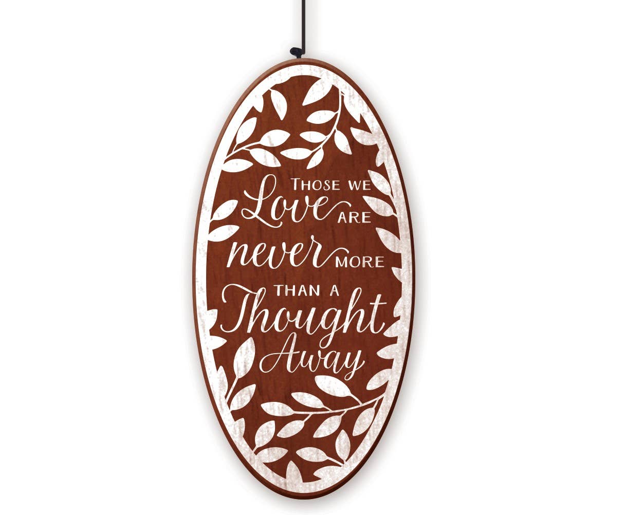 An oval wooden hanging sign with a brown background and white distressed text that reads, "THOSE LOVE ARE NEVER MORE THAN A THOUGHT AWAY"