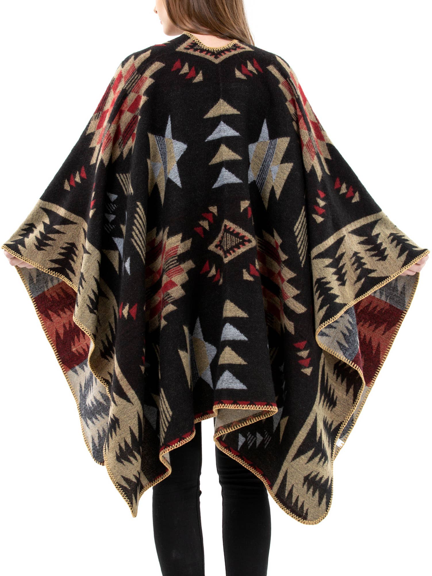 Person wearing a patterned poncho with geometric designs on a white background