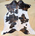 Cowhide named Stinger showing a white and black and brown brindle spotted pattern.